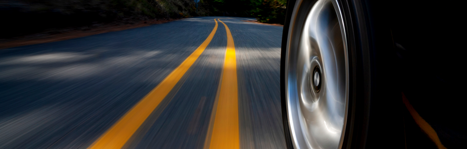 Car tire speeding on a curvy road.