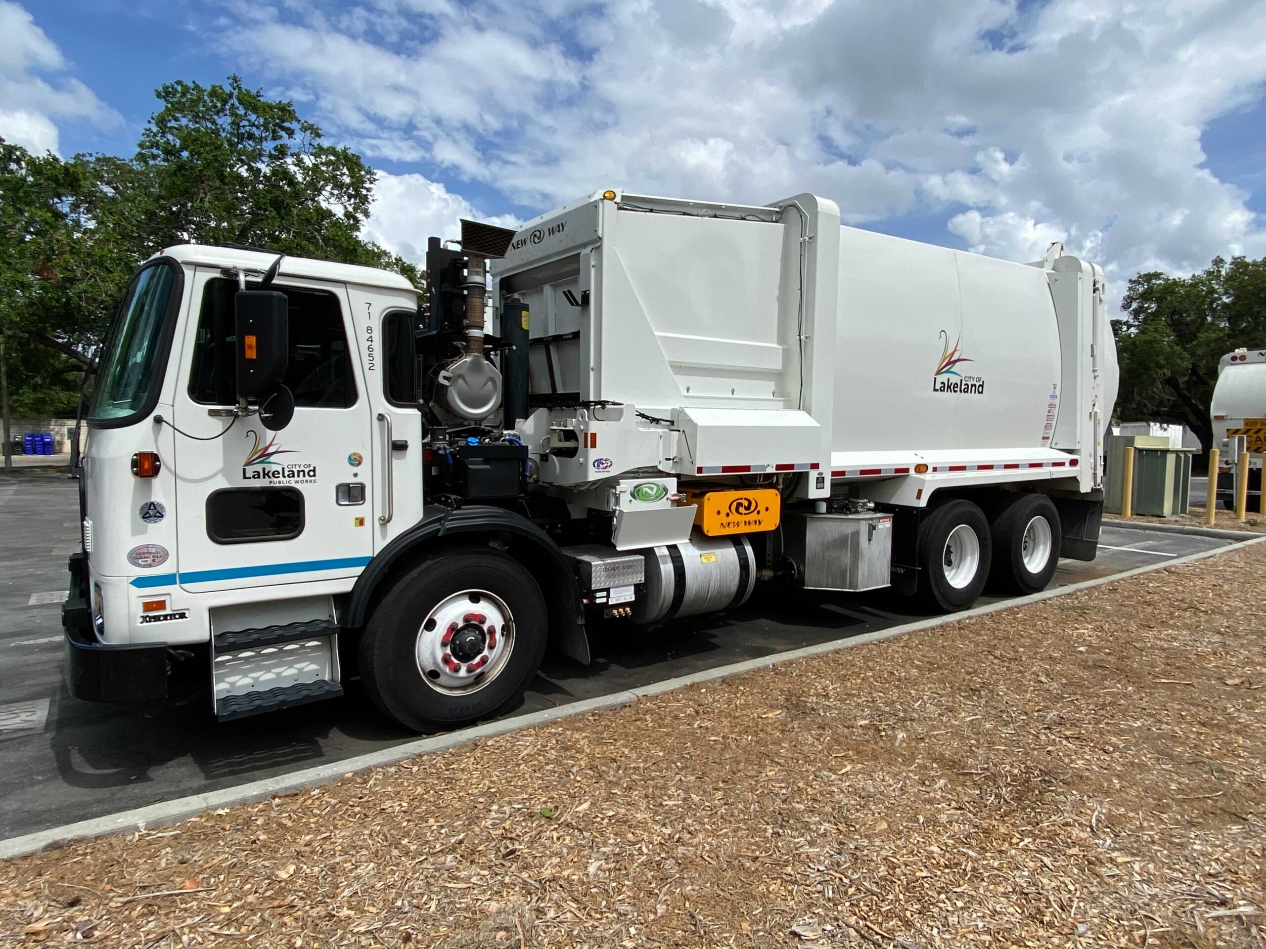 White Lakeland garbage truck parked outdoors.