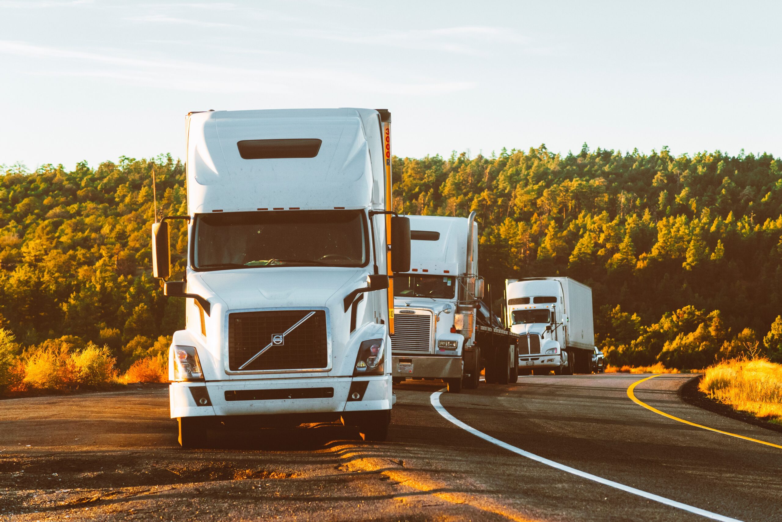 Semi trucks on highway at sunset